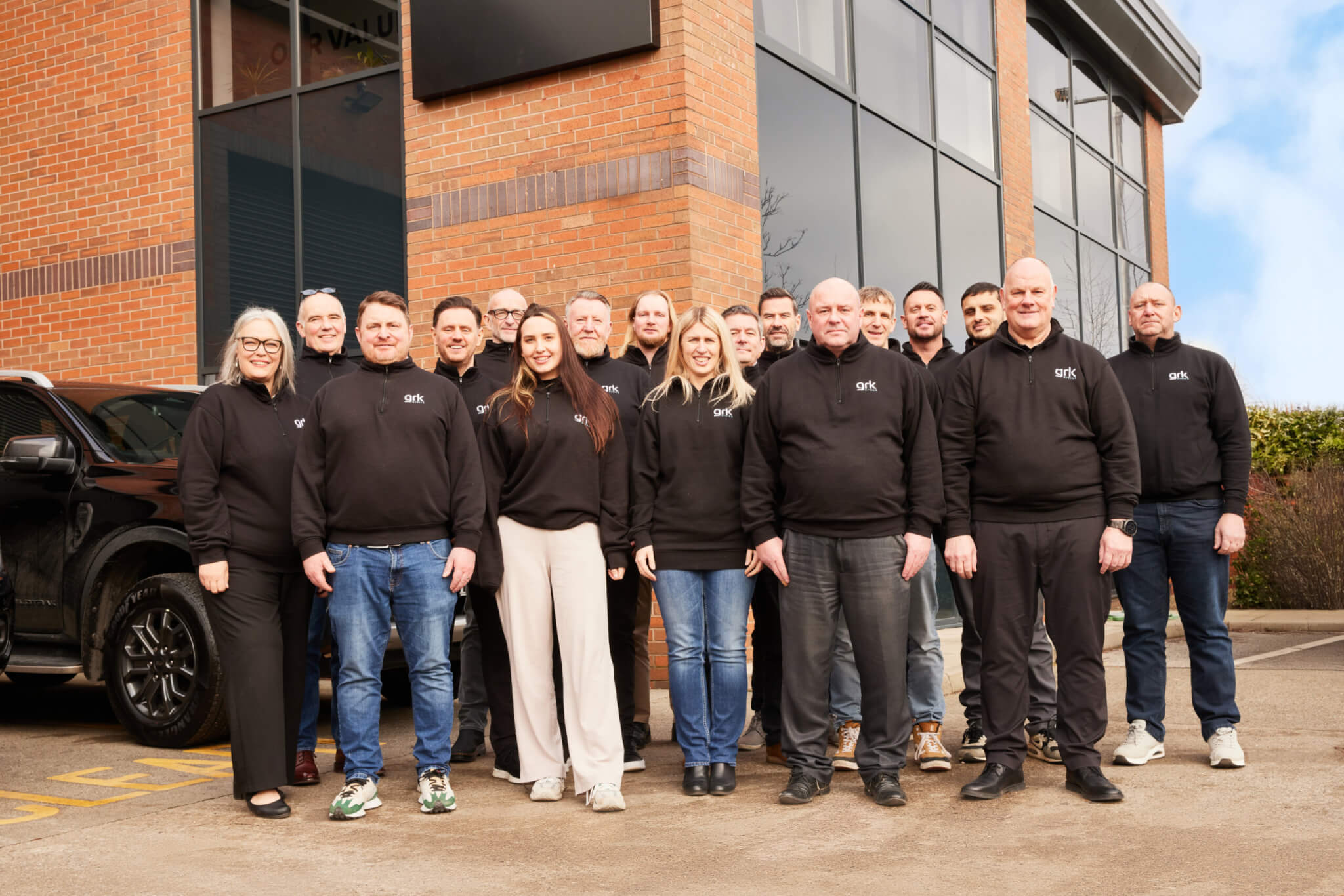The GRK Civils team are shown together outside of their office, all are wearing black GRK fleeces