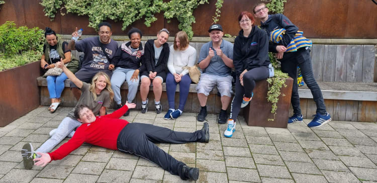 Members of Leeds Autism Awareness posing together on a bench by Leeds Docks.