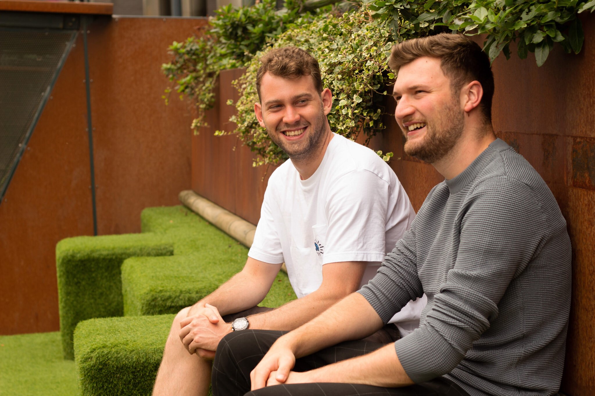 Co-founders Matt and Sam sit outside, looking outwardly at their view